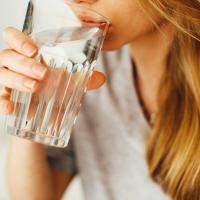 Kvinde der drikker et glas vand 